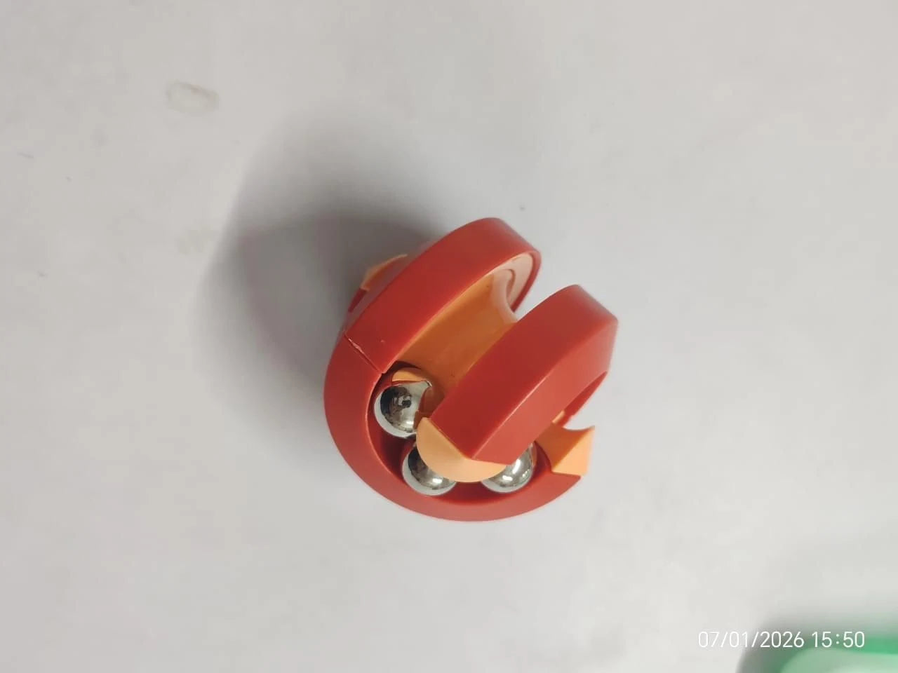 Red and orange mechanical component on a light gray background
