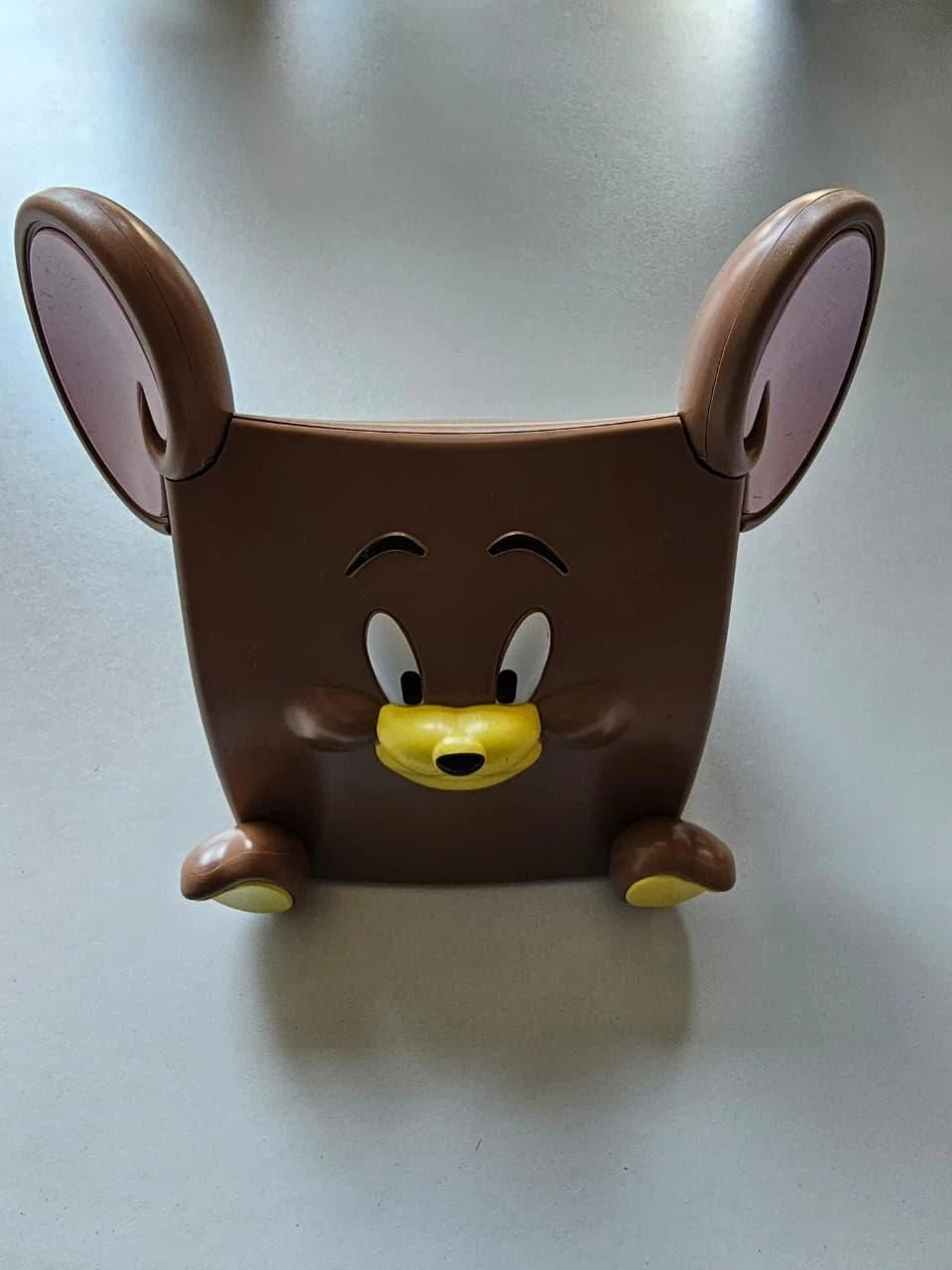Brown mouse-shaped container with a face on a light gray background