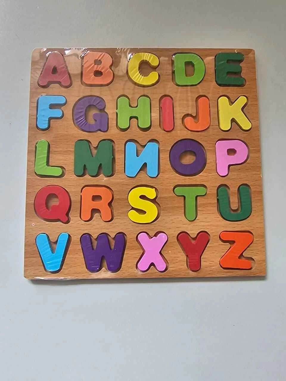 Wooden alphabet puzzle with colorful letters on a gray background