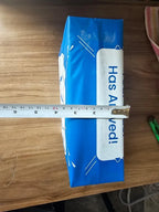 Blue package with 'Has Alived!' text on a wooden surface, measured by a ruler.
